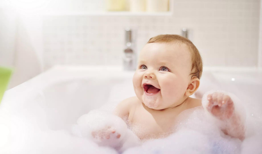 Bebek mutlu ve köpük ile banyo yapıyor